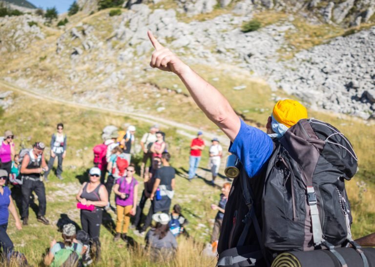 Hiking trekking in mountains leading group